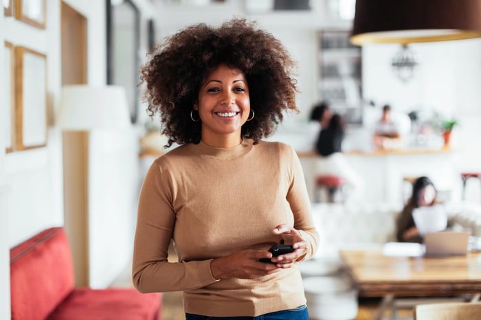 woman smiling in workspace beside customer quote for diversity and inclusion coaching